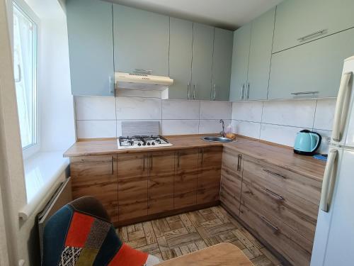 a kitchen with white cabinets and a wooden counter top at Shevchenko dvor in Kropyvnytskyi