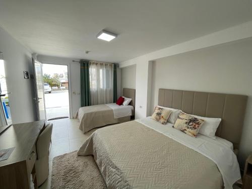 a hotel room with two beds and a television at Sofo Hotel Dhermi in Dhërmi