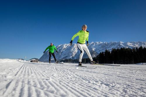 two people are skiing down a snow covered slope at B&B Hallstatt Lake OBERTRAUN self check in in Obertraun