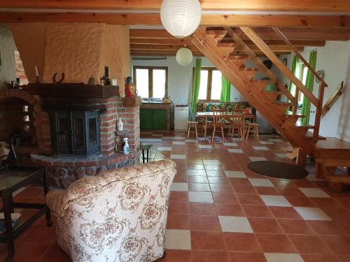 a living room with a fireplace and a staircase at Domek letniskowy na Mazurach in Miłomłyn