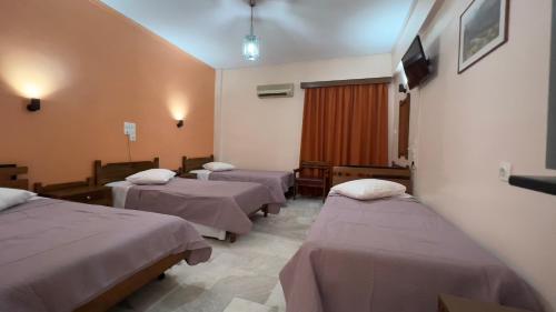 a hospital room with three beds and a tv at Hotel Cosmos in Athens