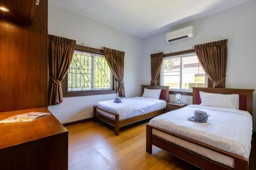 a hotel room with two beds and a desk at 5 Bedroom Pool Villa Close To Town H5 in Hua Hin