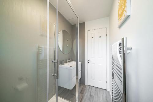uma casa de banho com um chuveiro, um lavatório e um espelho. em The Doric em Aberdeen