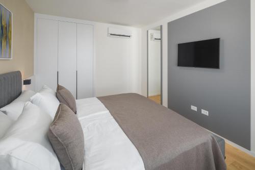 a bedroom with a bed with a television on the wall at Maj Luxury Residence in Poreč