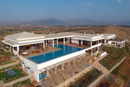 an aerial view of a house with a swimming pool at StayVista at Sunset on the Lake - Infinity Lakeview Swimming Pool with Contemporary Interiors & Lavish Amenities in Igatpuri