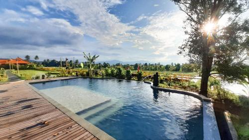 a swimming pool in a yard with a wooden deck at Sri Lestari Banyuatis in Munduk