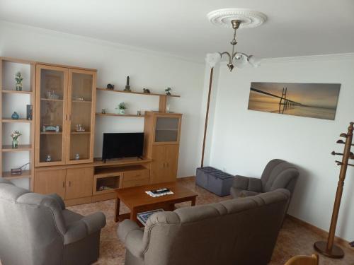 een woonkamer met 2 stoelen en een televisie bij Sandino 10 in Santiago de Compostela