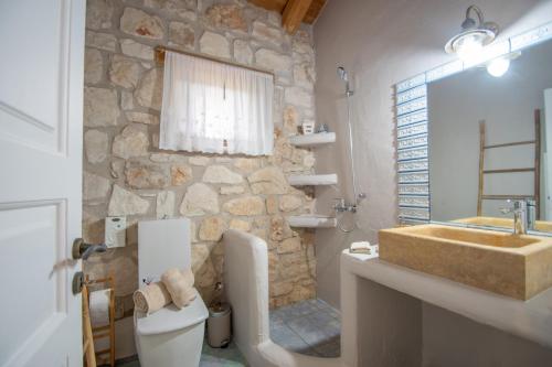 a stone bathroom with a sink and a toilet at Valory's House - The Stone House in Vasilikos
