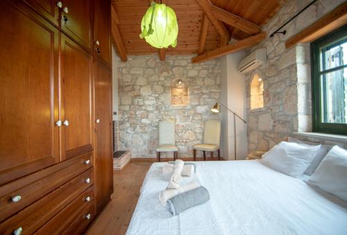 a bedroom with a large bed with a stone wall at Valory's House - The Stone House in Vasilikos