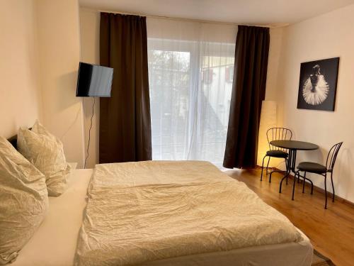 a bedroom with a bed and a window and a table at Appartement im Zentrum von Baienfurt in Baienfurt