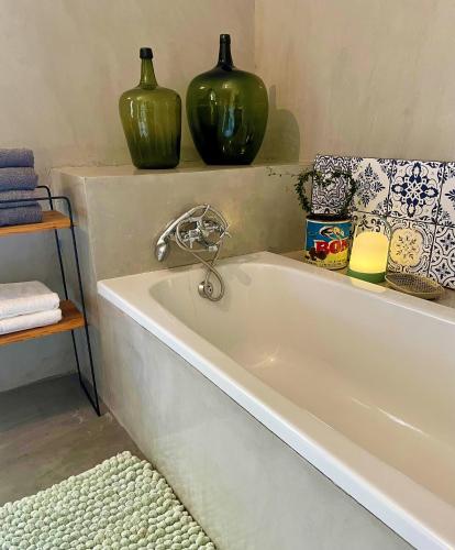a bath tub with two green vases on a shelf at Klipfontein Farm House in Molteno