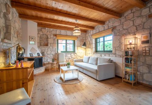 a living room with a couch and a stone wall at Valory's House - The Stone House in Vasilikos