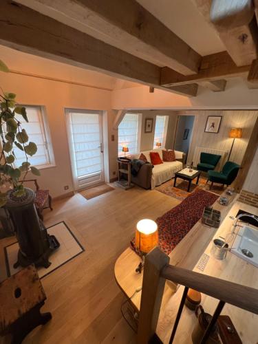 a living room with a couch and a table at Le gîte La Colonge, cosy et charmant in Glos-sur-Lisieux