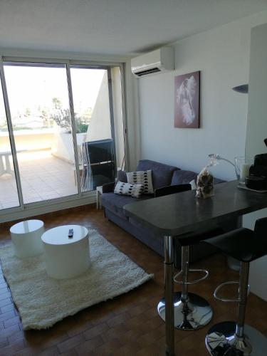 un salon avec un canapé et une table dans l'établissement Naturisme appartement heliopolis face à la plage avec vue mer, au Cap d'Agde