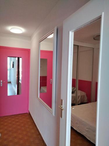 une chambre avec une porte rose et un lit dans l'établissement Naturisme appartement heliopolis face à la plage avec vue mer, au Cap d'Agde