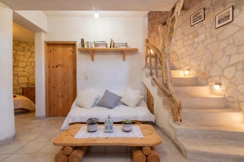 a room with a bed and a table and stairs at Gerakomylos Stone House in Vasilikos