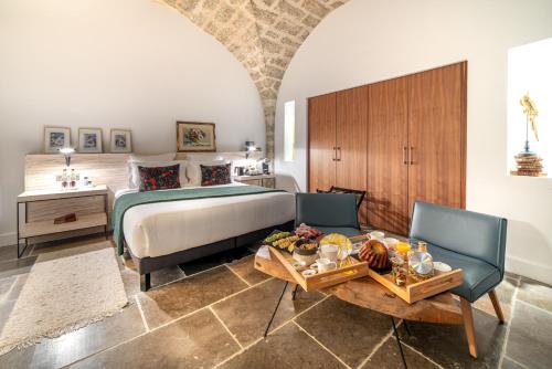 Les Chambres du Prieuré في بيزيناس: غرفة نوم بسرير وطاولة وكراسي