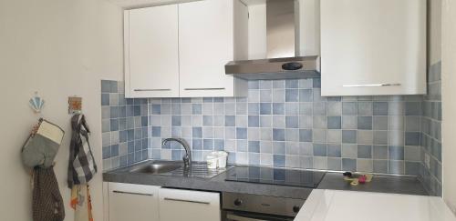 a kitchen with white cabinets and a sink at Residenze Coda Cavallo in San Teodoro