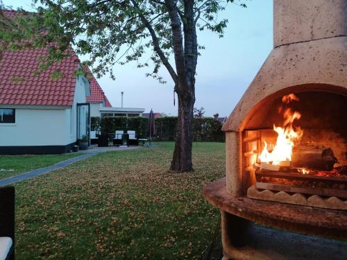 a fire oven in a yard with a house at Topsleep Villa Lathum in Lathum