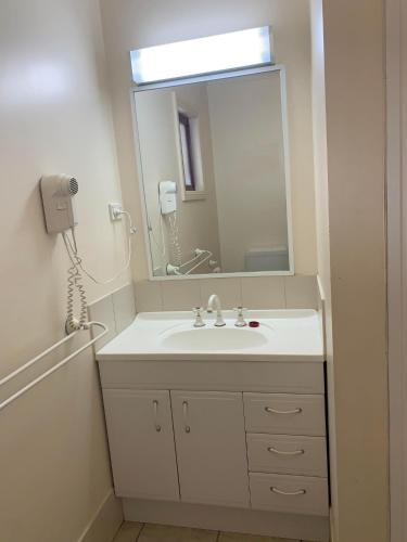 un baño con lavabo y espejo en Outback Quarters Motel Hay and Restaurant, en Hay
