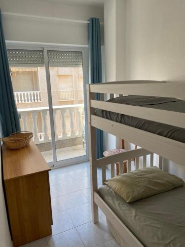 pokój z dwoma łóżkami piętrowymi i oknem w obiekcie El Acequion Appartement 4 personnes à 100m plage w mieście Torrevieja