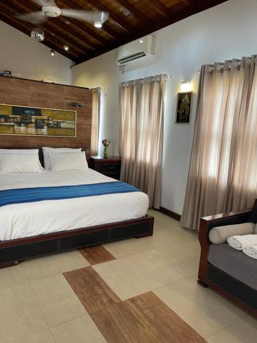 Atrium Leisure في Boralesgamuwa: غرفة نوم بسرير كبير وأريكة