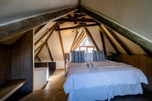 ein Schlafzimmer mit einem großen Bett im Dachgeschoss in der Unterkunft Shack on Supers in Jeffreys Bay