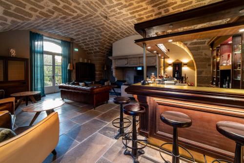 a bar with a counter and stools in a room at Les Chambres du Prieuré in Pézenas
