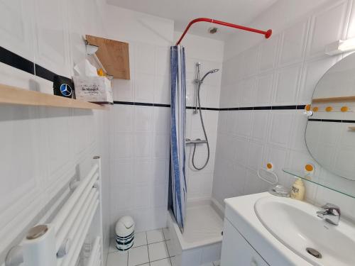 une salle de bain blanche avec une douche et un lavabo dans l'établissement REF 035 - Belle maison en pierre pour quatre personnes proche Golfe du Morbihan ARZON, à Arzon