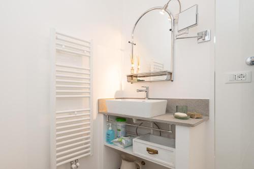 Cottage on the Lake by Holiday Solutions في ليتْسّينو: حمام أبيض مع حوض ومرآة