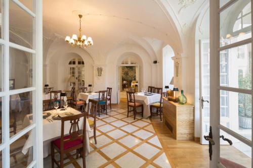 uma sala de jantar com mesas, cadeiras e janelas em Hotel Villa Alberti Portofino Land em Santa Margherita Ligure