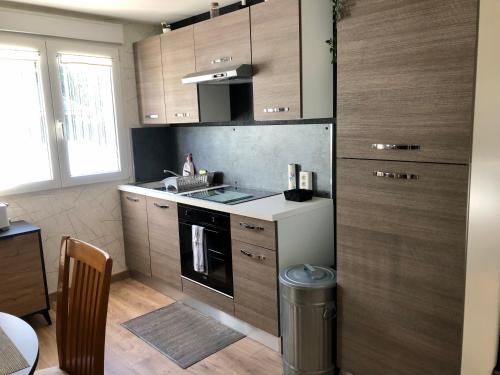 a kitchen with wooden cabinets and a stove top oven at L’annexe in Lunéville