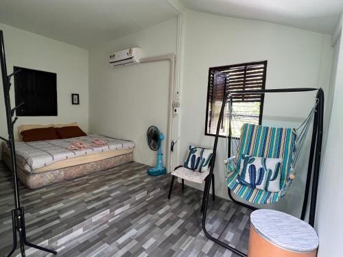 a bedroom with a bed and a chair in it at Pano Solar Guest House (พาโน โซล่า เกสเฮ้าส์ ) in Trat