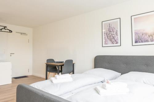 a bedroom with two white beds and a desk at Landschaftliches Haus in Tönning
