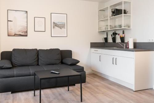 a living room with a couch and a kitchen at Landschaftliches Haus in Tönning