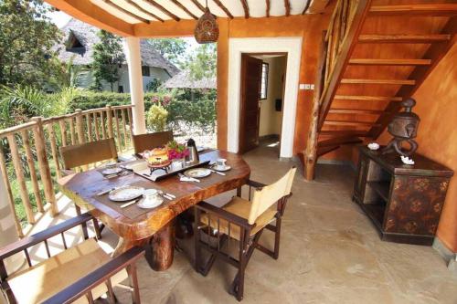a wooden table and chairs on a patio at Villa Ndoto in Diani Beach