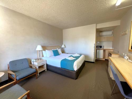 una camera d'albergo con letto e sedia di Goulburn Central Motel a Goulburn