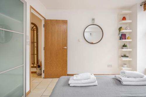 a room with two towels on a bed with a mirror at Central Holborn, lovely and bright apartment for 4 in London