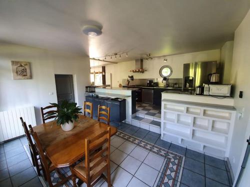 cocina con mesa de madera y sillas en una habitación en Propriété de campagne, en Vierzon