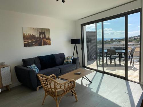 un salon avec un canapé et une table dans l'établissement BLUE AGOSTA, à Grosseto-Prugna