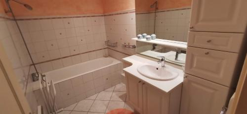 La salle de bains est pourvue d'un lavabo et d'une baignoire. dans l'établissement Logement hyper centre Champagnole (jura), à Champagnole