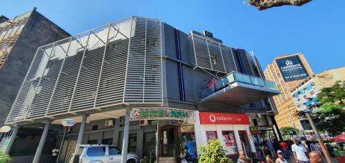 a building on a street with people walking around it at Hotel Royal Residencial in Maputo