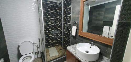 y baño con lavabo, aseo y ducha. en Hotel Royal Residencial en Maputo