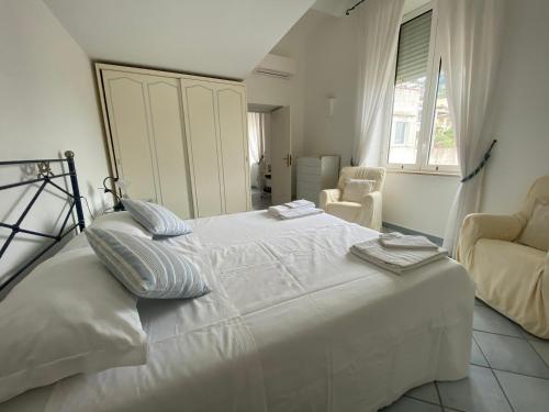 um quarto com uma grande cama branca e uma janela em Regina di Capri - Sopramonte - em Capri