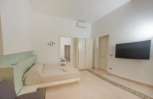 Schlafzimmer mit einem Bett und einem Flachbild-TV in der Unterkunft Lecce Santa Chiara Terrace piano rialzato in Lecce