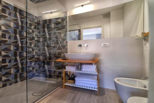 a bathroom with a sink and a glass shower at Lo Scoglio della Formica B&B in Capo dʼOrlando