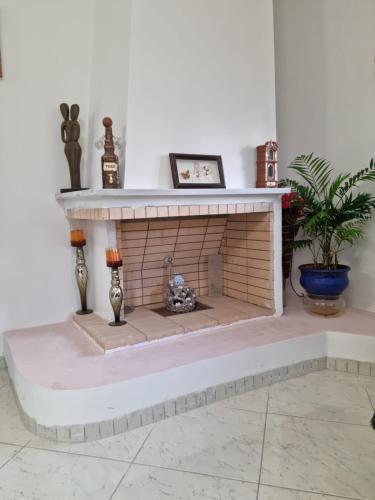 a living room with a fireplace with a teddy bear inside at LiriKa's airport house in Artemida