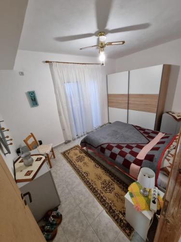 a bedroom with a bed and a ceiling fan at LiriKa's airport house in Artemida