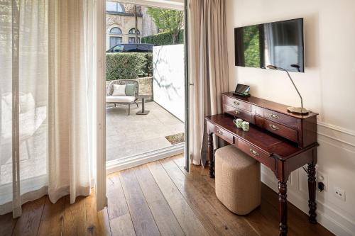 a room with a wooden table and a window at De Tuilerieën - Small Luxury Hotels of the World in Bruges