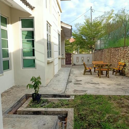 a courtyard of a house with a table and a bench at Gambang Homestay BangloMuslim in Kuantan